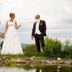 Brautpaar steht vor Teich