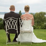 Sitzendes Brautpaar schaut auf Seepanorama